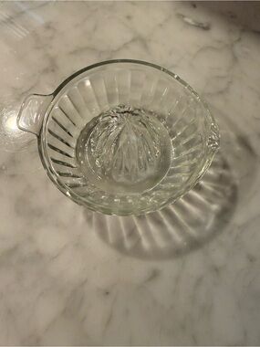 vintage clear glass manual citrus orange juicer with a ribbed reamer and handle